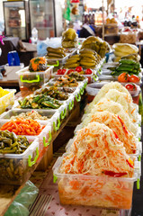 Various pickles and marinated vegetables on the market. Sauerkraut, pickled cucumbers, eggplants, tomatoes, apples