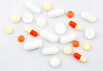 Pharmacy theme. Pills and Capsules on the White Surface. Closeup.