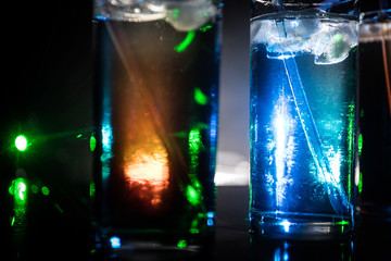 collection of colorful shots with lemon on bar; set of alcohol mini cocktail shooters with lime;