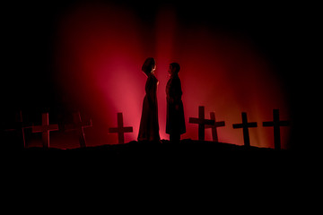 Fototapeta premium Halloween. Scary zombie bride on a night cemetery holds a pumpkin lantern.