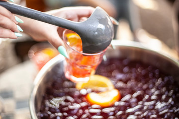 The girl pours a punch into a glass. Party in the open air. Light alcoholic drinks for friends. Rest in the city with drinks.
