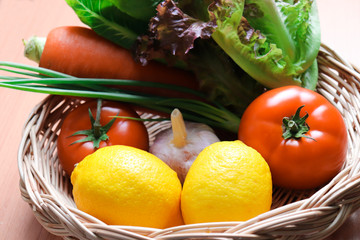 Mixed Fresh colorful vegetables in a wicker basket include Lemon salad tomato garlic carrot Scallion close up