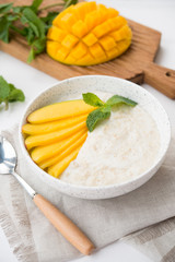 Oatmeal bowl with fresh mango. Healthy breakfast.