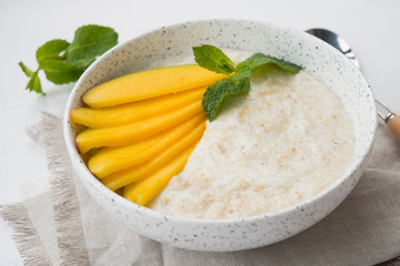Oatmeal bowl with fresh mango. Healthy breakfast.