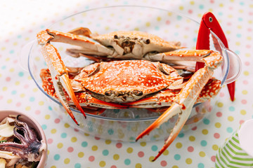 Steamed Fresh Flower Crabs in glass bowl with red crab cracker.