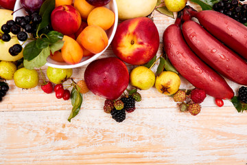 Flat lay of fruits over white wooden background, top view. Vegetarian, vegan, dieting, clean eating, weight loss ingredients.  Summer fruit food background. Copy space.