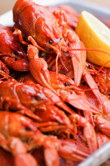 A lot of  bright red boiled  crawfish with lemon