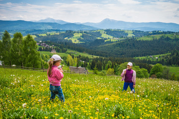 Fototapeta na wymiar Children walking in the flowering meadow