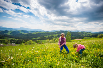 Fototapeta na wymiar Children walking in the flowering meadow