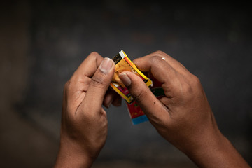 Close up of a man hand tearing the Chewing tobacco, Gutka or gutkha in India. - obrazy, fototapety, plakaty