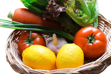 Mixed Fresh colorful vegetables in a wicker basket include Lemon salad tomato garlic carrot Scallion close up
