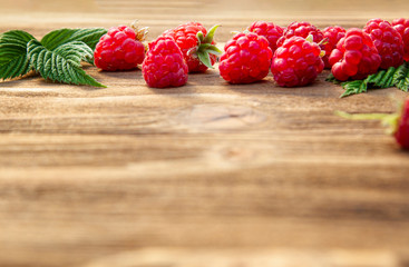 Ripe raspberries from the garden on an old wooden background.Copy space