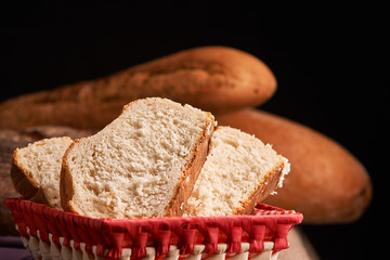 Bakery - gold rustic crusty loaves of bread and buns on black chalkboard background. Still life captured from above