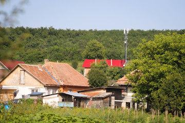 Fototapeta na wymiar 4G and 5G antennas in a village, between houses and heavy vegetation in rural Romania