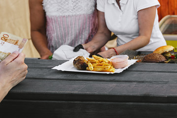 Chef making beef burgers outdoor on open kitchen food festival event. Street food ready to eat on a food stall.