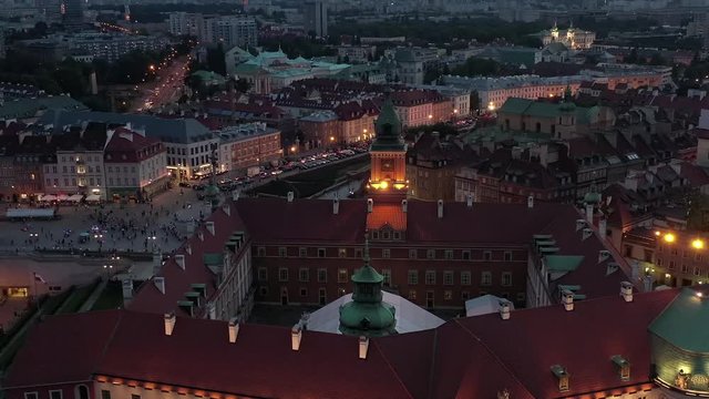 Drone shot at the royal palace in the old town of Warsaw at night. Aerial view on Facade of the palace is beautifully lit with lanterns. 4K