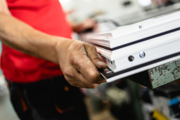 Manual worker assembling PVC doors and windows. Manufacturing jobs. Selective focus. Factory for aluminum and PVC windows and doors production.