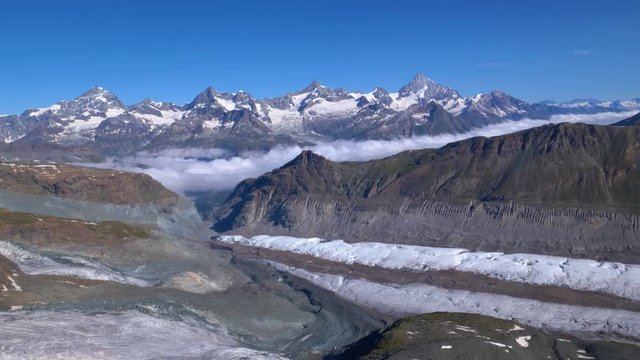 Aerial sideways shot over Schwarzgletscher and Gornergletscher glaciers, camera tilting up. Zermatt area, Switzerland