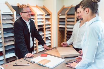 Salesman explaining options for colors and materials of new kitchen