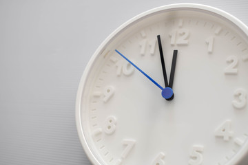 Clock face showing twelve o'clock with white background. White round wall clock. Twelve o'clock. Midday or midnight. 12 a.m. or 12 p.m