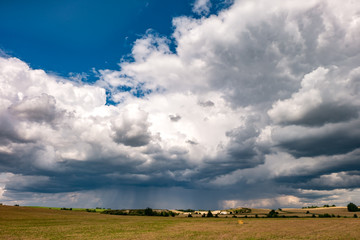 hdr panorama on asphalt road among fields in evening with awesome black clouds before storm