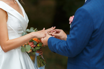 Obraz na płótnie Canvas Newlyweds put each other rings on the ceremony