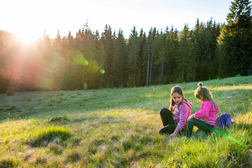 Cheerful children bathed in the evening sun on the edge of the forest