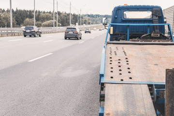  Tow truck towing a broken down car on the highway