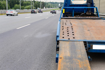  Tow truck towing a broken down car on the highway