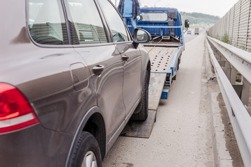  Tow truck towing a broken down car on the highway