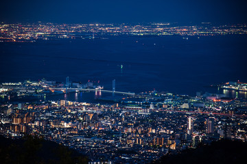 Fototapeta na wymiar Night view of Kobe and Osaka Bay which see from viewpoint on Rokko mountain in Kobe, Japan. Travel in Japan concept. Night view of bay, bridge and building
