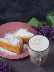 Coffee latte in a glass glass glass glass with a piece of cake cozy atmospheric background with flowers