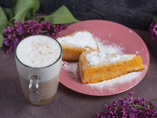 Coffee latte in a glass glass glass glass with a piece of cake cozy atmospheric background with flowers