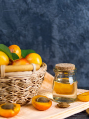 Apricot natural oil and apricots on a wooden table
