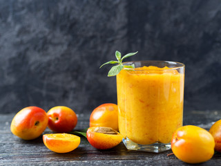 Summer delicious Apricot smoothie in a glass on a wooden background