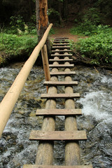 Dangerous trail through a waterfall with wooden ladders in the Slovak Paradise National Park,...
