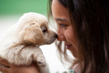 Niña con cachorro de Golden Retriever. Complicidad. Mascota.