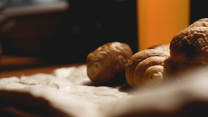Freshly baked croissants with orange juice on kraft paper. Closeup photography of fresh delicious dessert for breakfast.