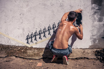 Graffiti artist painting a wall in the street