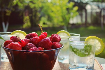 cherries in bowl on wooden table in garden