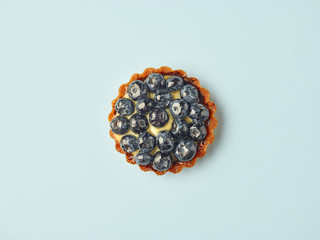 blueberry tart on light blue background