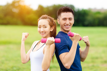 Obraz premium asian young couple training with dumbbells
