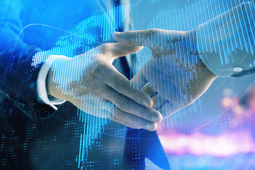 Double exposure of world map on cityscape background with two businessmen handshake. Concept of international business