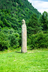 Stone idol of the 8th century on a background of green forest, Arkhyz, Karachay-Cherkessia, Russia