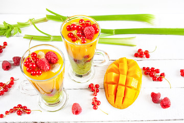 Kolorowe wielowarstwowe smoothie z mango, kiwi, selerem naciowym, porzeczkami i malinami