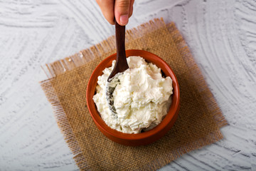 Homemade white butter - Girl hands holding a clay bowl with freshly prepared white butter in home