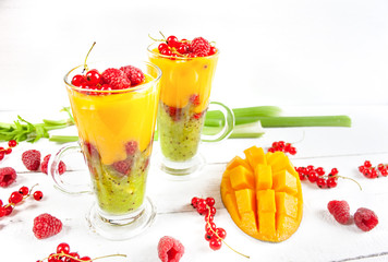 A multi-layered smoothie with mango, kiwi, celery, currants and raspberries