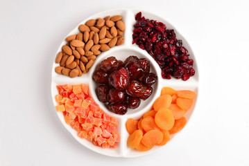 Mix of dried fruits and nuts. Apricot, raisin, cranberry, dates fruit. Isolated on a white background. Space for text or design.