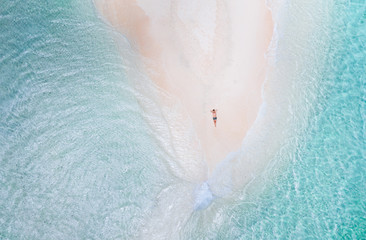 Naked island view from the sky. Man relaxing taking sunbath on the beach.shot taken with drone above the beautiful scene. concept about travel, nature, and marine landscapes