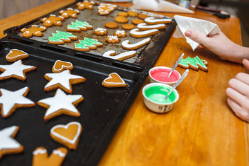 Handmade decorating of festive gingerbread cookies in the form of stars, snowflakes, people, socks, staff, mittens, Christmas trees, hearts for xmas and new year holiday. preparation for holidays